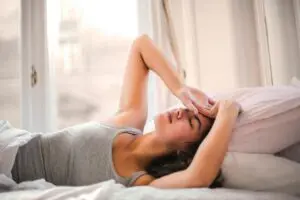  Photo by Andrea Piacquadio: https://www.pexels.com/photo/woman-in-gray-tank-top-lying-on-bed-3768582/ woman lying down, just waking up tired 