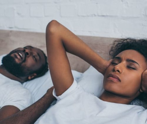 man snoring wife covering ears